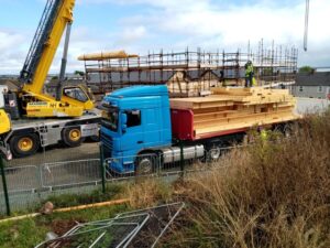A Truck with wooden beams and a crane at the construction site of the new Wexford Rape Crisis Building