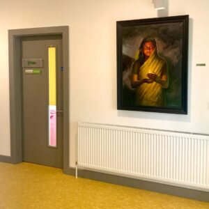 A hallway with a door and a painting of a hindu women